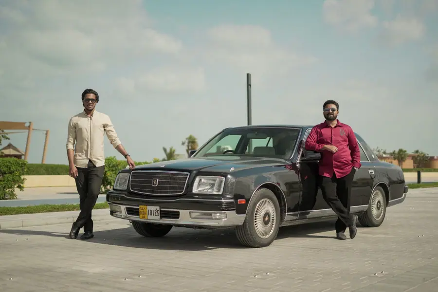 Muhammed Shafad and a friend standing beside a black Toyota Century