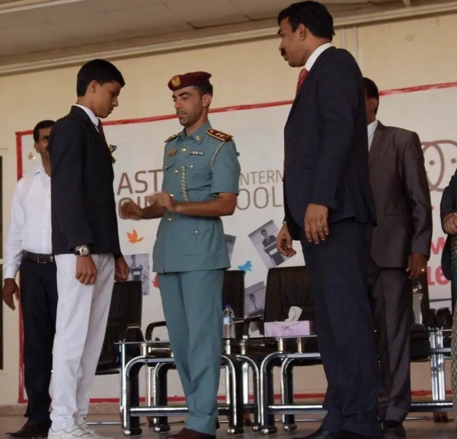 A young Muhammed Shafad receiving a school leadership badge on stage